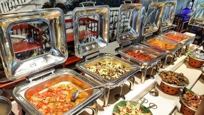 A buffet with various food options, including a section for fried chicken and a section with a variety of dishes. - Sky Beach D20 Nha Trang Hotel (Nha Trang)