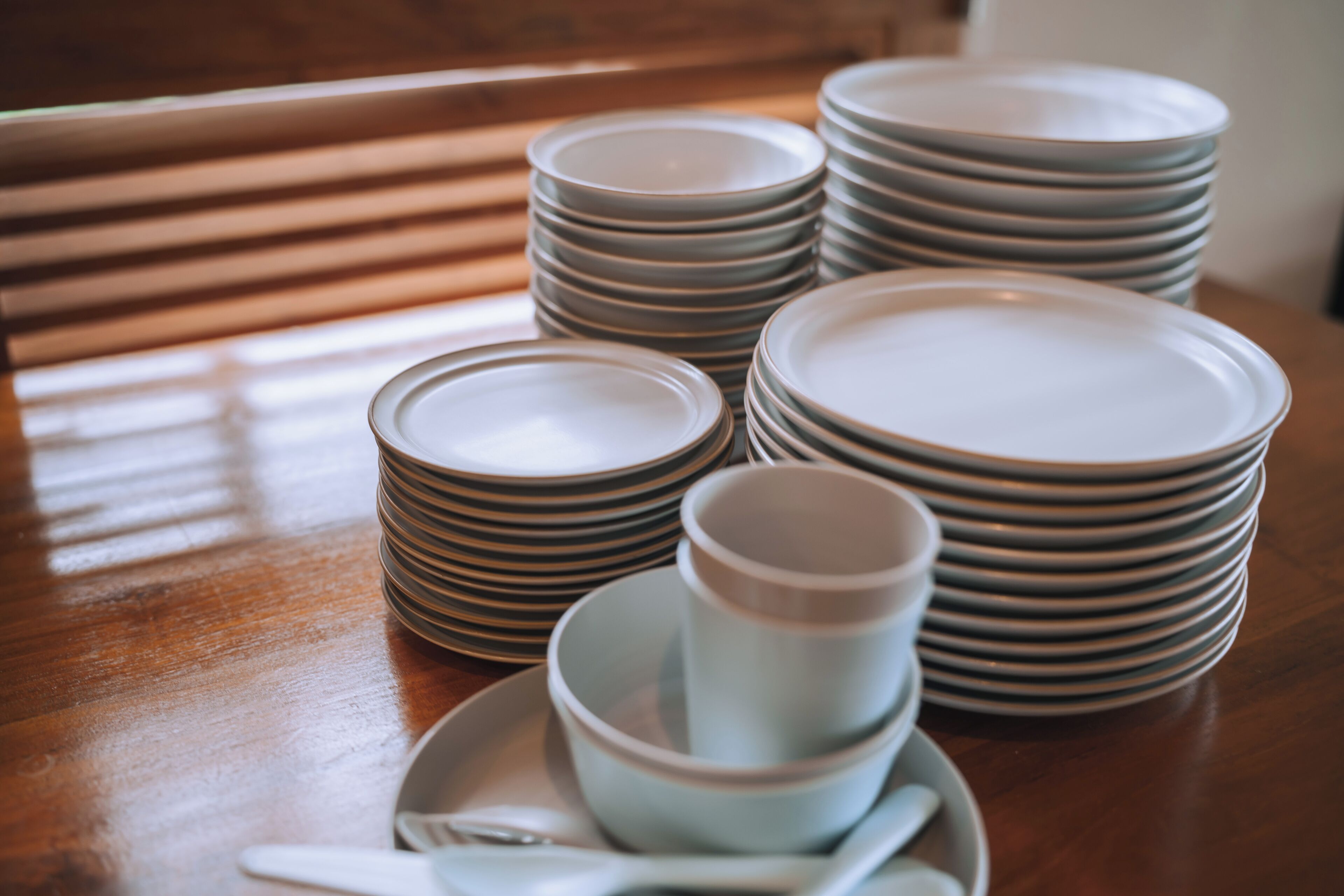 Une pile d’assiettes et de bols sur une table en bois.