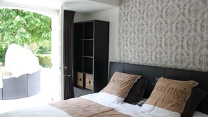 A bedroom with a bed, a wardrobe, and a view of greenery outside.