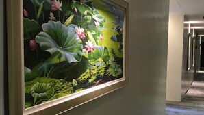A framed painting of water lilies on a wall in a hallway. - Blue Lotus Hotel Davao (Davao)