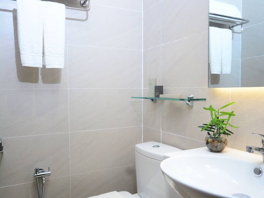 Une salle de bain comprenant des toilettes, une étagère en verre, un lavabo et un miroir.