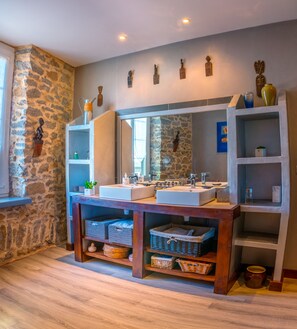 A bathroom with two sinks, stone walls, and wooden shelves. - VERY NICE STONE TOWN HOUSE WITH HEATED POOL (Carcassonne)