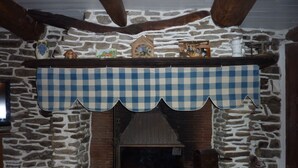 Ein Kamin aus Stein mit karierter Konsole, einer Holzbank und einer rustikalen Steinwand.