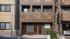 A modern multi-story building with a flat facade, large windows, and a visible entrance. - Plat Hostel Keikyu Asakusa Karin (Tokyo)
