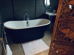 Tina con regadera, secadora de cabello, toallas, papel de baño 