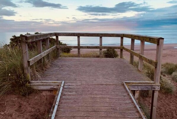 Walk along the boardwalk to the sandy beach.