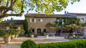 A stone building with a courtyard, outdoor seating, and a well-maintained garden. - LA MAISONNETTE DE ROBINSON HILLSIDE VIEW IDEAL FOR TWO!  (L Isle Sur La Sorgue)