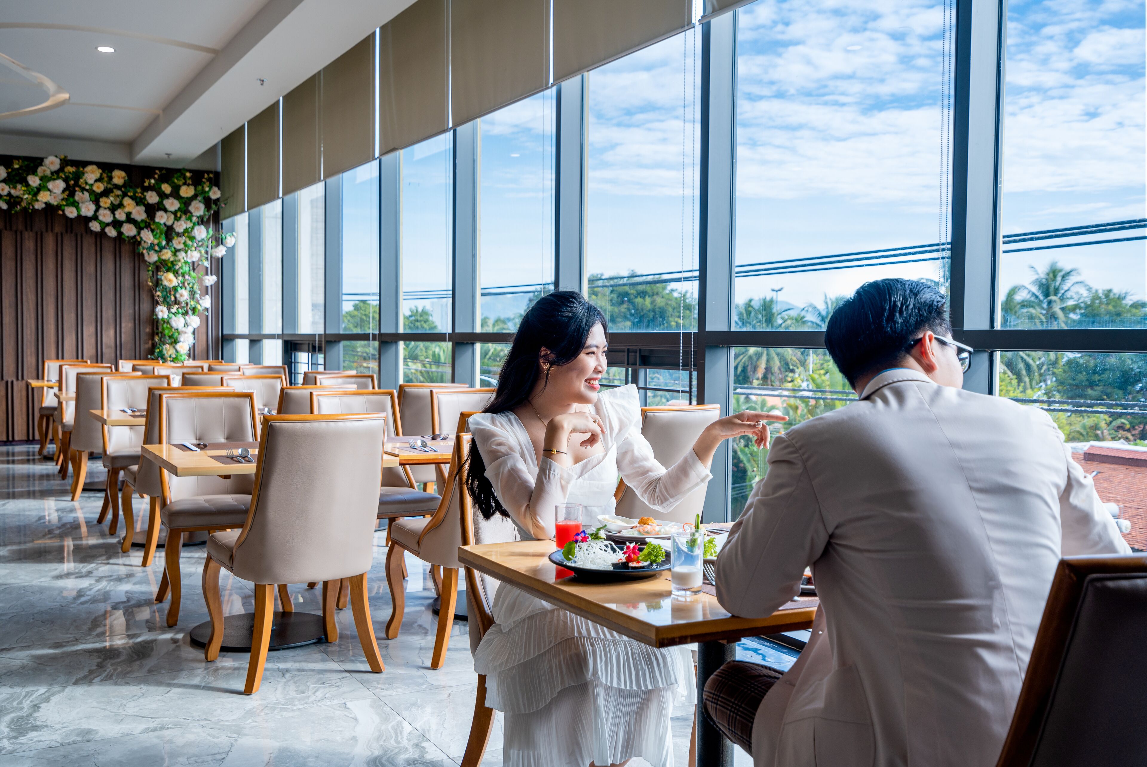 A restaurant with a modern interior, large windows, and a view of the outdoors.