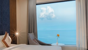 A hotel room with a large window offering a view of the sea and a clear sky. - Vesna Hotel Nha Trang (Nha Trang)