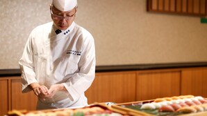A chef in a white uniform with a hat, preparing food on a counter. - Yamashiro Onsen Miyabi no Yado Kaga Hyakumangoku (Kaga)
