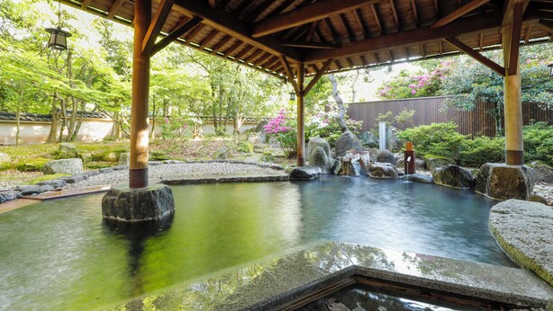 A traditional Japanese onsen with a wooden pavilion, a stone hot spring, and a tranquil garden setting. - Yamashiro Onsen Miyabi no Yado Kaga Hyakumangoku (Kaga)