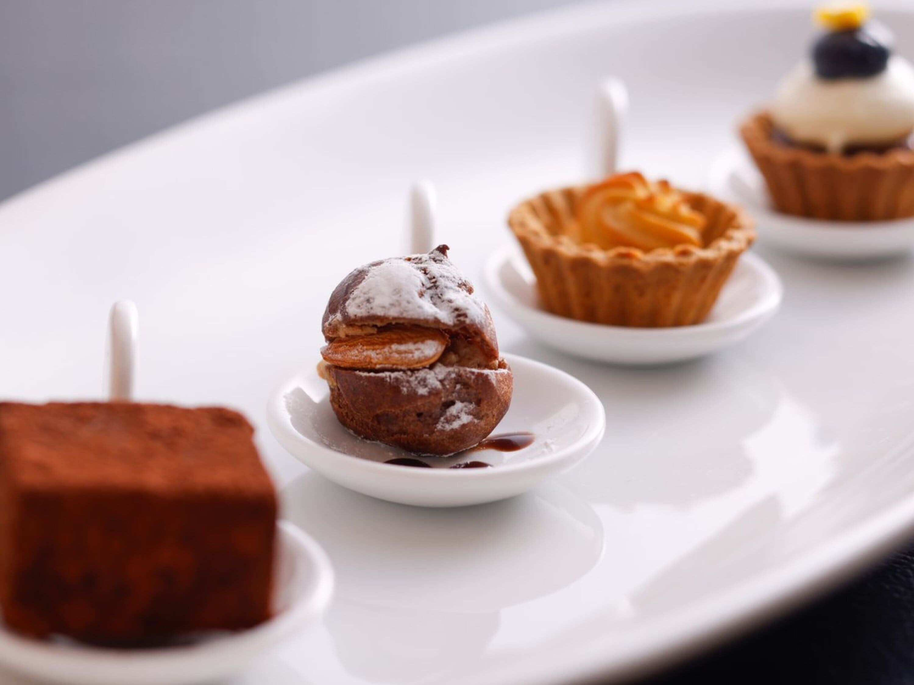 Un plato de postres con diversas opciones, incluyendo un postre de chocolate, una tartaleta y un cupcake.