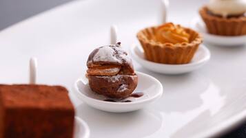 Un plato de postres con diversas opciones, incluyendo un postre de chocolate, una tartaleta y un cupcake.