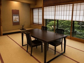 Ein traditioneller japanischer Raum mit Tatami-Böden, einem niedrigen Tisch und verschiebbaren Shoji-Türen.