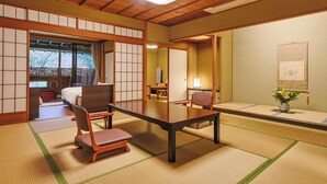 A traditional Japanese room with tatami flooring, a low table, chairs, and sliding doors. - Yamashiro Onsen Miyabi no Yado Kaga Hyakumangoku (Kaga)