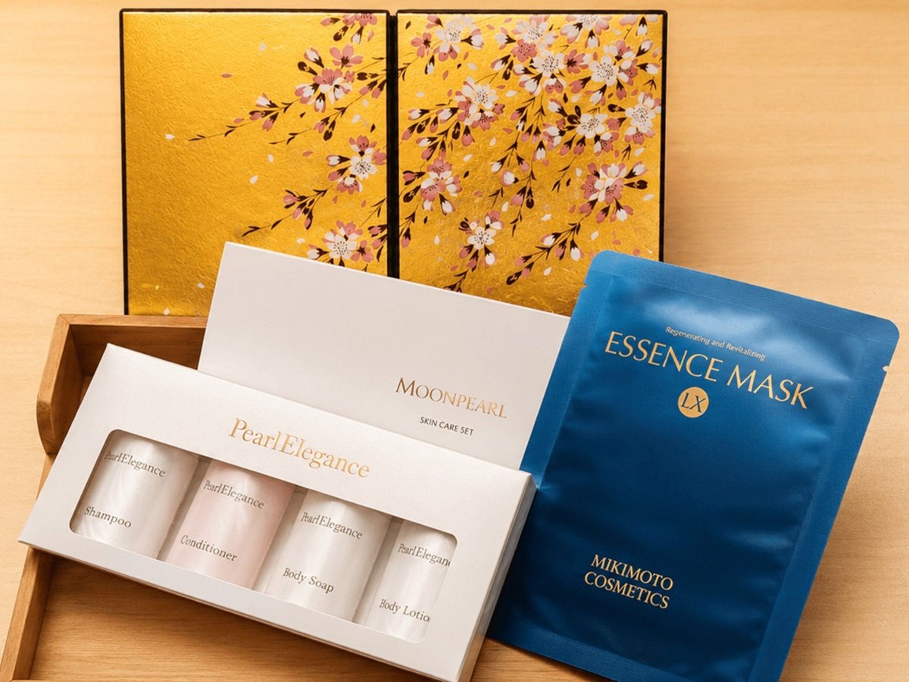 Set de cuidado facial que incluye una caja con el rótulo 'MOONPEARL' y una bolsa azul con el rótulo 'ESSENCE MASK'.