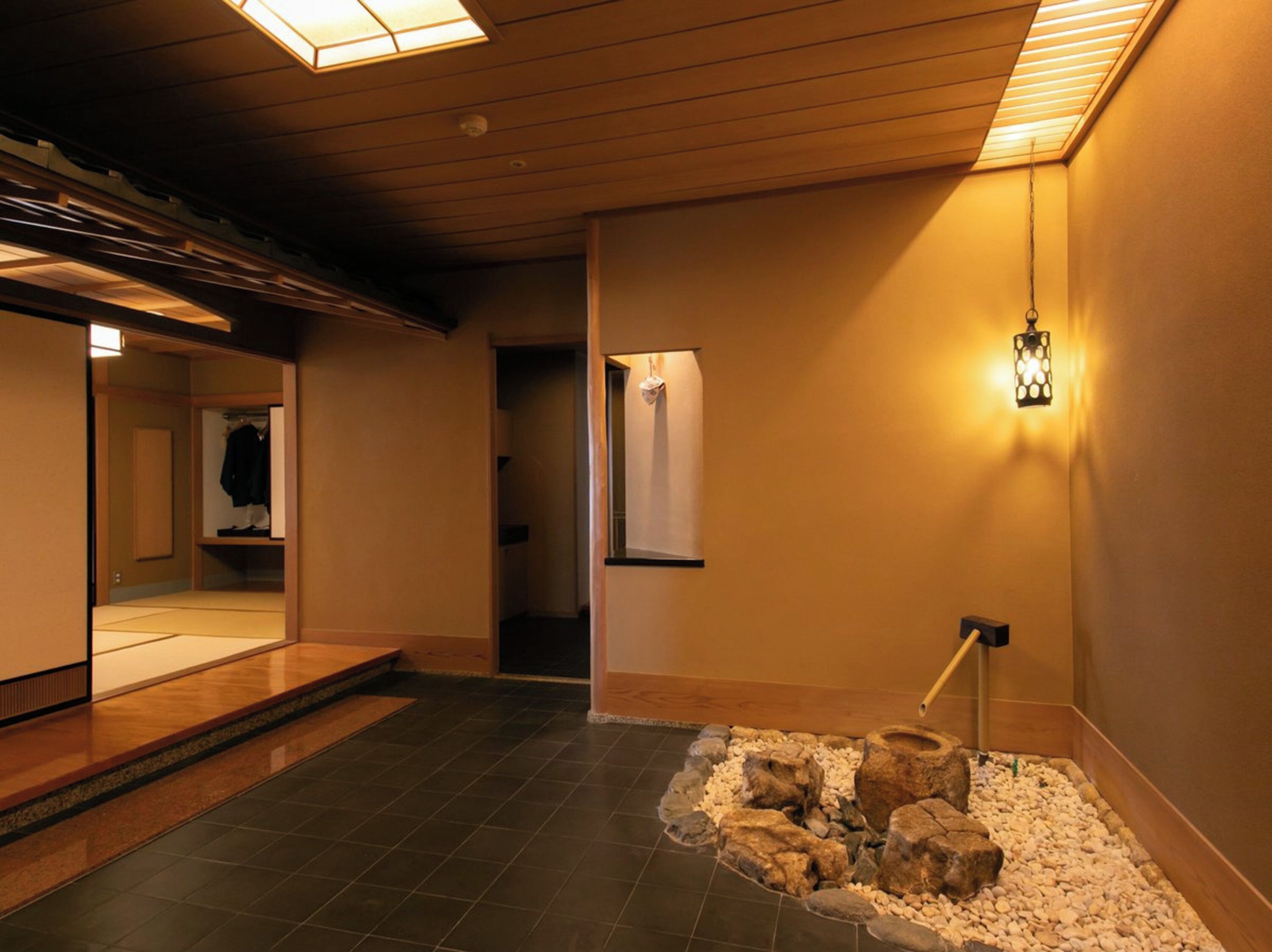 A traditional Japanese interior with a tatami mat floor, a shoji screen, and a stone lantern.