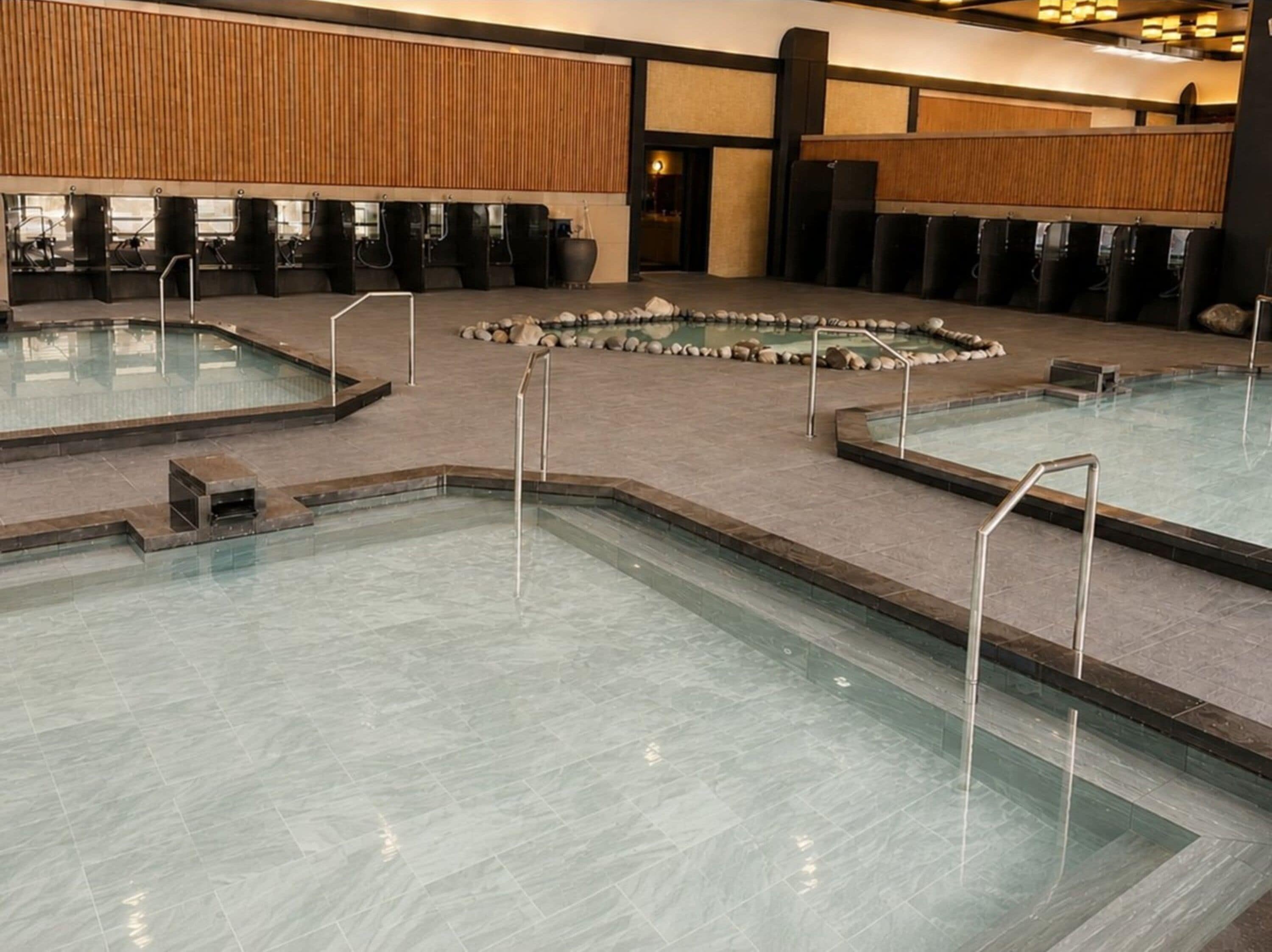 Uma área de piscina com várias piscinas e um mosaico de pedra.