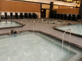 Uma área de piscina com várias piscinas e um mosaico de pedra.