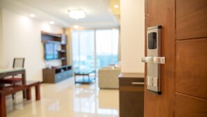 A modern interior with a wooden door, a kitchen area, and a dining space. - Nice Residence Hotel Bangkok (Bangkok)