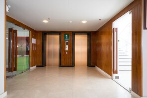 Een modern lifthok met houten lambrisering en een overzichtelijke indeling.