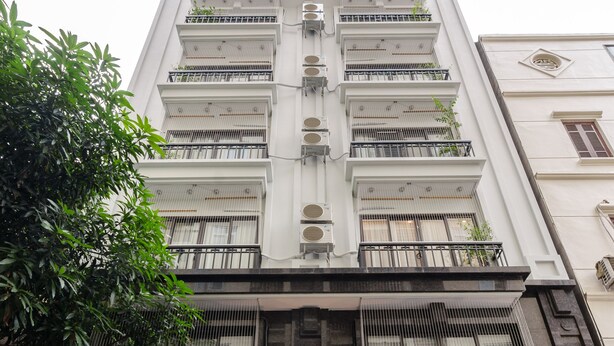 Un hôtel à plusieurs étages, doté d’une façade moderne, de grandes fenêtres et d’une entrée bien éclairée.