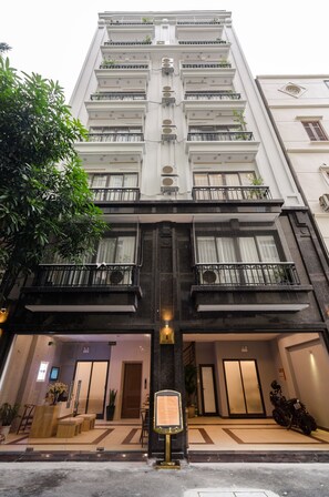 A multi-story hotel with a modern facade, large windows, and a well-lit entrance. - Fukurai Boutique Apartments Ha Noi (Hanoi)