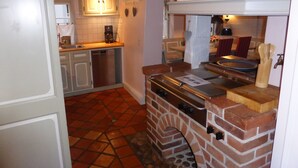 Eine kleine Küche mit Backofen, Kaffeemaschine und Spüle.