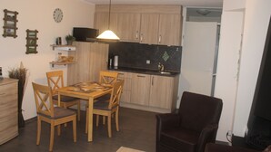 A compact living space with a dining area, kitchen, and seating area. - Modern semi-detached house on the North Sea for up to 4 people (Butjadingen)