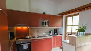 Una cocina moderna con una isla central, electrodomésticos de acero inoxidable y un ventanal que proporciona luz natural.