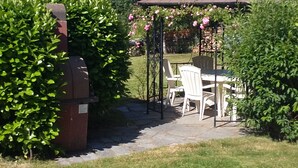 A patio area with a grill, outdoor seating, and a pergola with flowers. - Magnificent spacious apartment with WIFI, ideal for PMR. 3-star rating. (Xonrupt-Longemer)