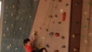 A person climbing a multi-colored indoor rock climbing wall with various holds. - Magnificent spacious apartment with WIFI, ideal for PMR. 3-star rating. (Xonrupt-Longemer)