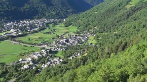 A small village with houses clustered on a hillside, surrounded by lush greenery and mountains. - Rental three-room apartment in Saint Lary (Vignec)