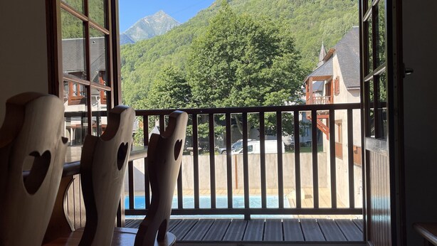 A balcony with a view of a mountain and a pool area. - Rental three-room apartment in Saint Lary (Vignec)