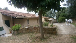 Ein rustikales Haus mit Ziegeldach, Steinmauer und kleinem Garten.