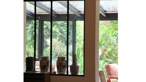 A room with a large window overlooking a garden, a sofa, and a chair. - Large house with plenty of charm (Aureilhan)