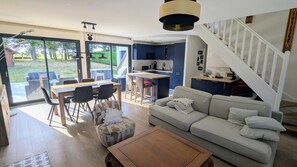 A modern living room with a sofa, coffee table, and dining area with chairs and a table. - Charming country house near Saint-Valery-Sur-Somme, 6 people (Arrest)
