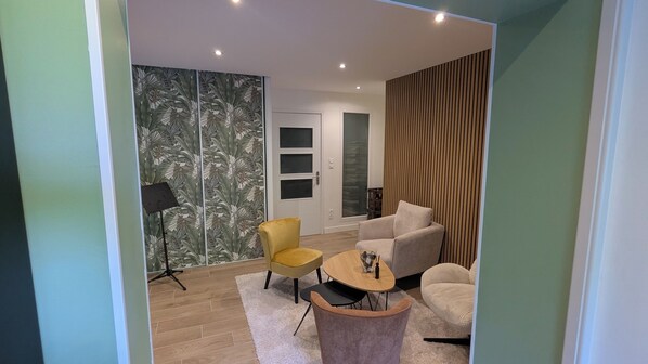 A modern living room with a sofa, armchair, and a small coffee table.