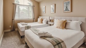 A hotel room with two beds, a window with blinds, a small table with a lamp, and framed pictures on the wall. - Sunshine Retreat-Hot Tub,Massage Chair,Espresso&EV (Bend)