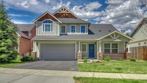 A two-story house with a garage, a front porch, and a well-maintained lawn. - Sunshine Retreat-Hot Tub,Massage Chair,Espresso&EV (Bend)