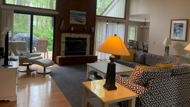 Un salón amplio con chimenea, ventanas grandes y un área de estar acogedora.