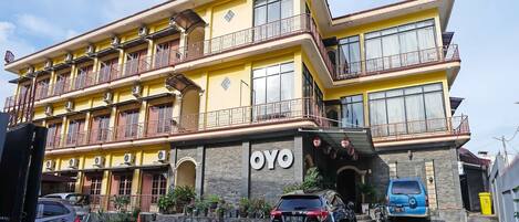 Un edificio de varios pisos con balcones y un cartel que dice "WISMA EMAT L".