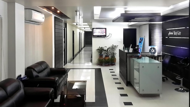Un hall d’hôtel moderne avec un comptoir d’accueil, un espace salon et un écran de télévision.