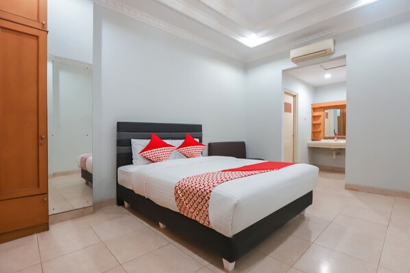 Relax in a spacious room with a large bed, wardrobe, and en-suite bathroom.