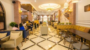 A hotel lobby with a checkered floor, seating areas, a reception desk, and a chandelier. - Prague Hotel Vung Tau (Ho Chi Minh City)