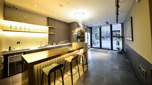 A modern bar area with a counter, stools, and a shelf with bottles. - MIJU HOUSE Gubei-a small white building beside Shanghai oil painting sculpture institute (Shanghai)