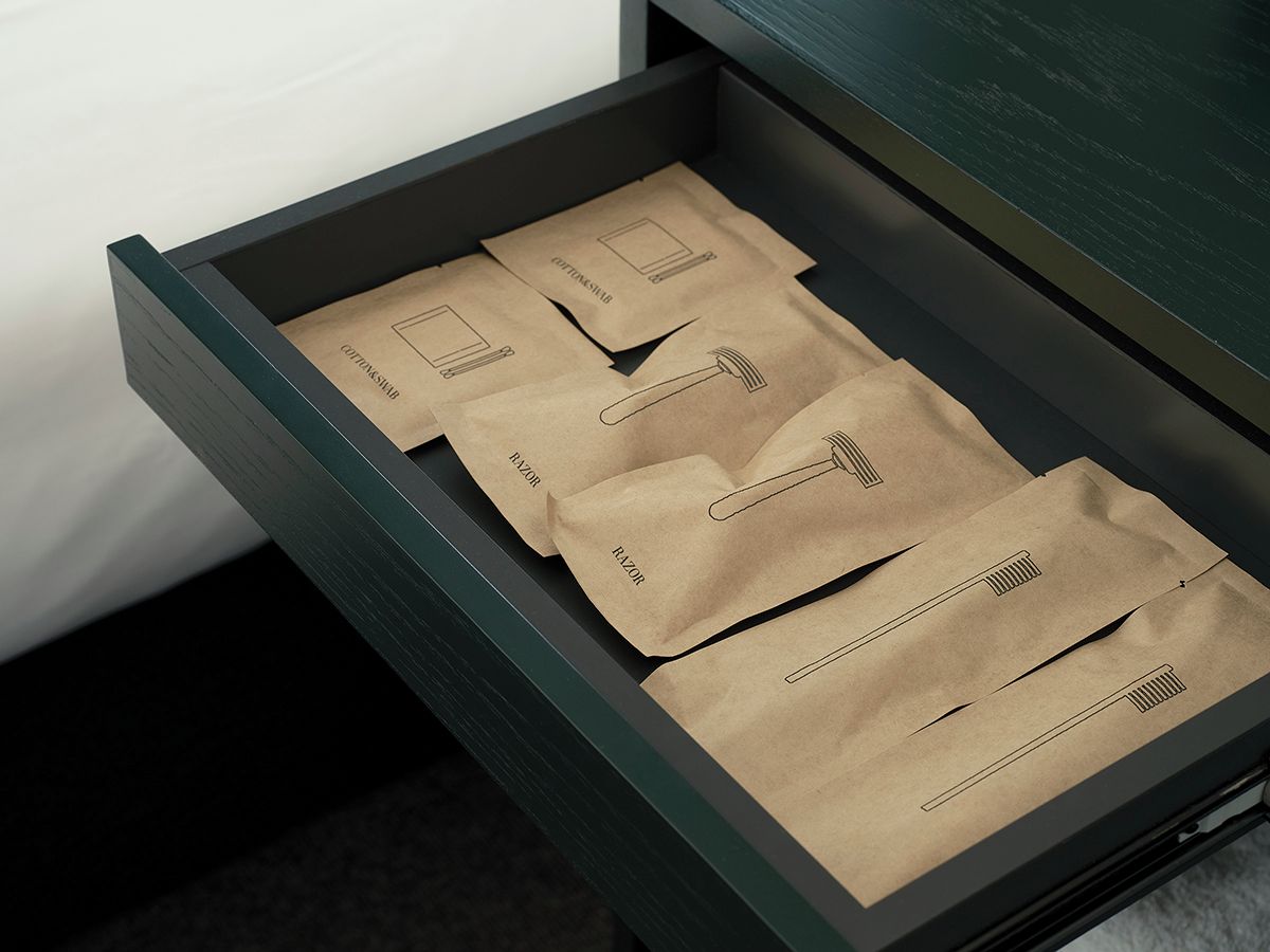 Uma gaveta com sacos de papel castanho etiquetados 'COTTONSHIRT' e 'RAZOR'.