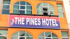 A hotel sign with the name "The Pines Hotel" and a partial view of the building's architecture. - The Pines Hotel (Kampung Raja)