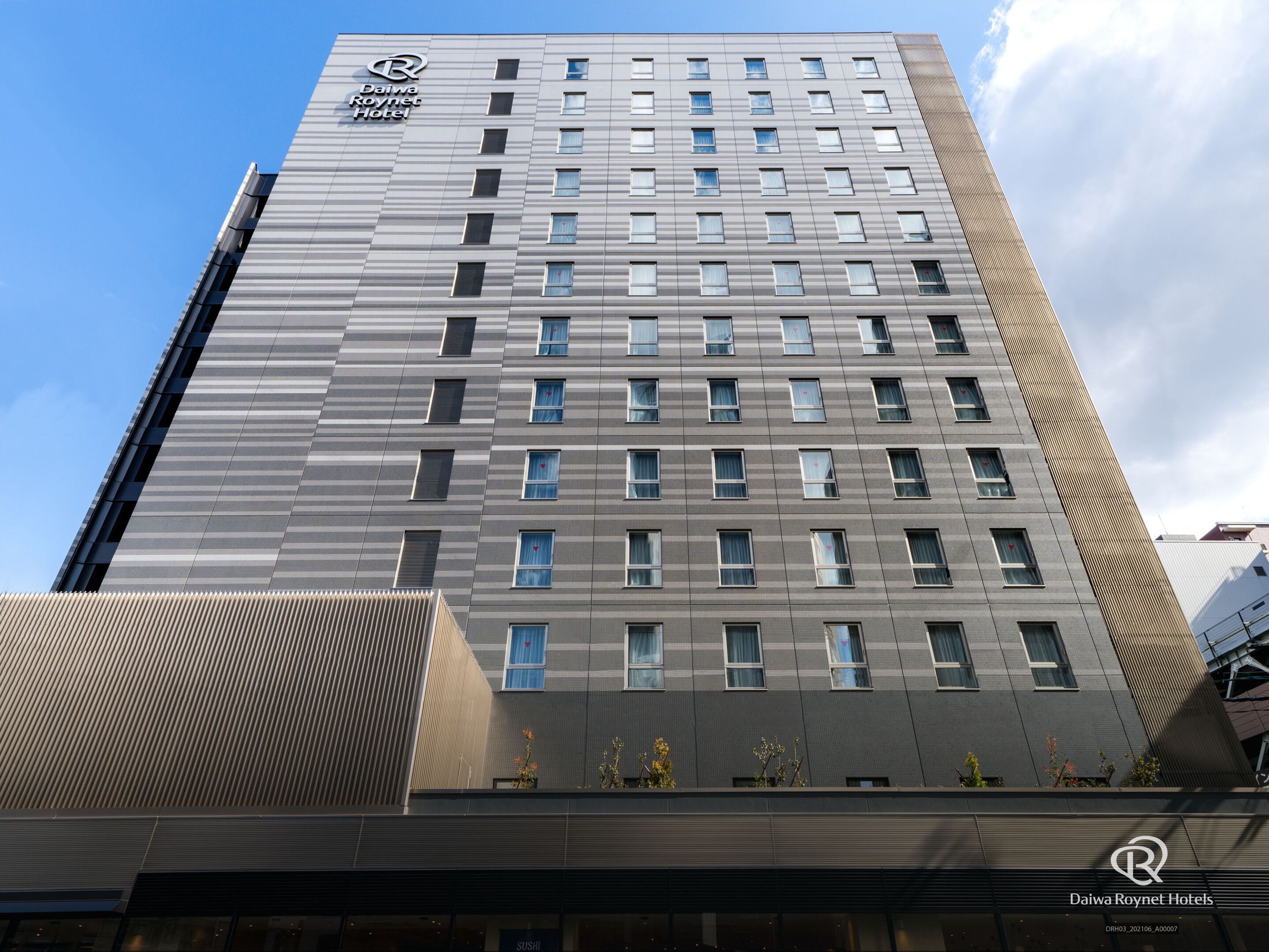 Edificio del hotel Daiwa Roynet con un diseño moderno, con varias ventanas y el logotipo bien visible.