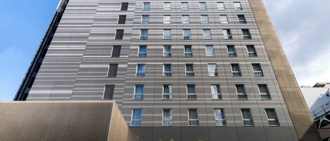 A Daiwa Roynet Hotel building with a modern design, featuring a series of windows and a visible logo.